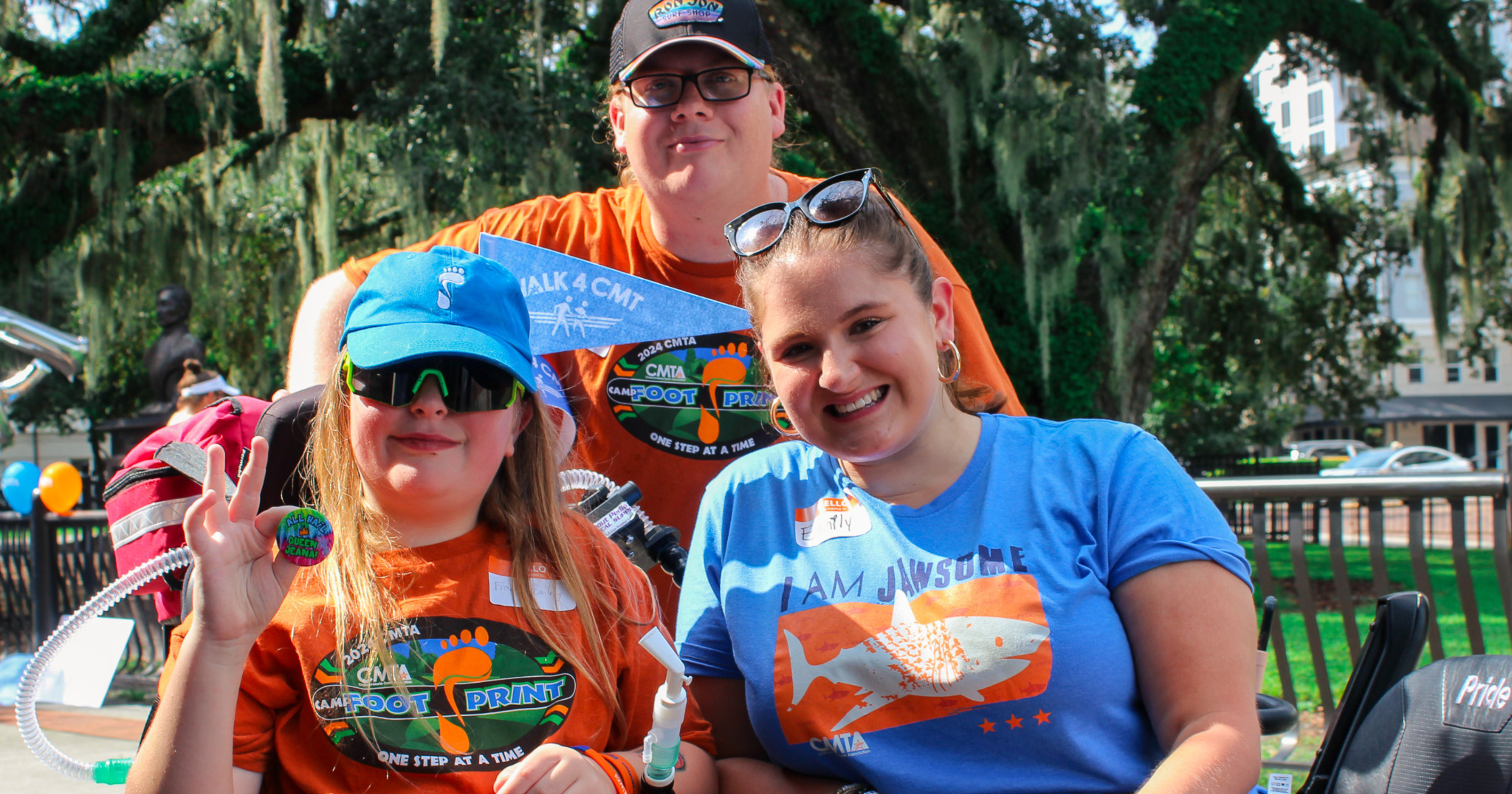 Three individuals posing for the camera at a local Walk 4 CMT event. One youth, one young adult, and one adult. 