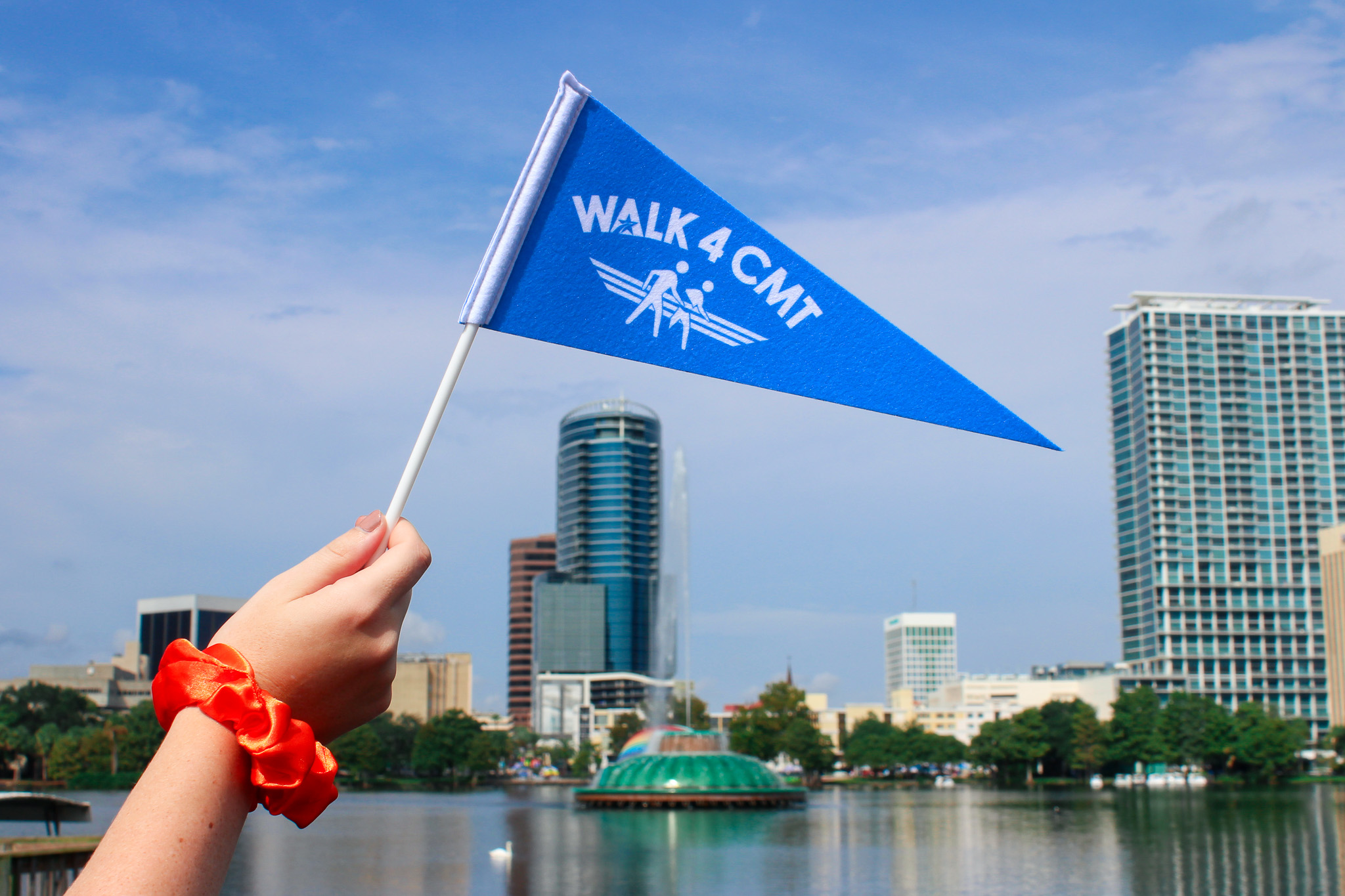 Walk4CMT flag being waved in fron tof a city skyline